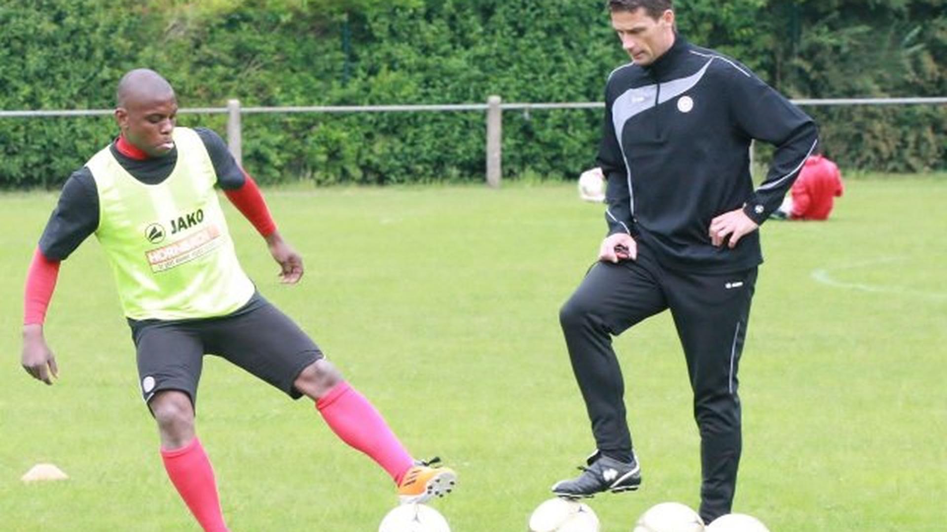 L'attaquant du Fola Joël Kitengé et l'entraîneur-adjoint Mike Ney