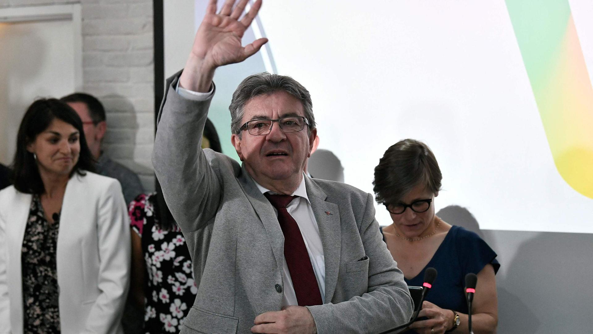 France's leftist La France Insoumise (LFI) party leader, Member of Parliament and leader of left-wing coalition Nupes (Nouvelle Union Populaire Ecologique et Sociale - New Ecologic and Social People's Union) Jean-Luc Melenchon waves during the election evening at the Nupes headquarters, following the first round of France's parliamentary elections in Paris, on June 12, 2022. - The united left (25% to 26.2%) and President Macron's camp (25% to 25.8%) came neck and neck in the first round of legislative elections on June 12, 2022, against a backdrop of record abstention (52.1% to 52.8%), opening up the game for the second round in a week. (Photo by STEPHANE DE SAKUTIN / AFP)