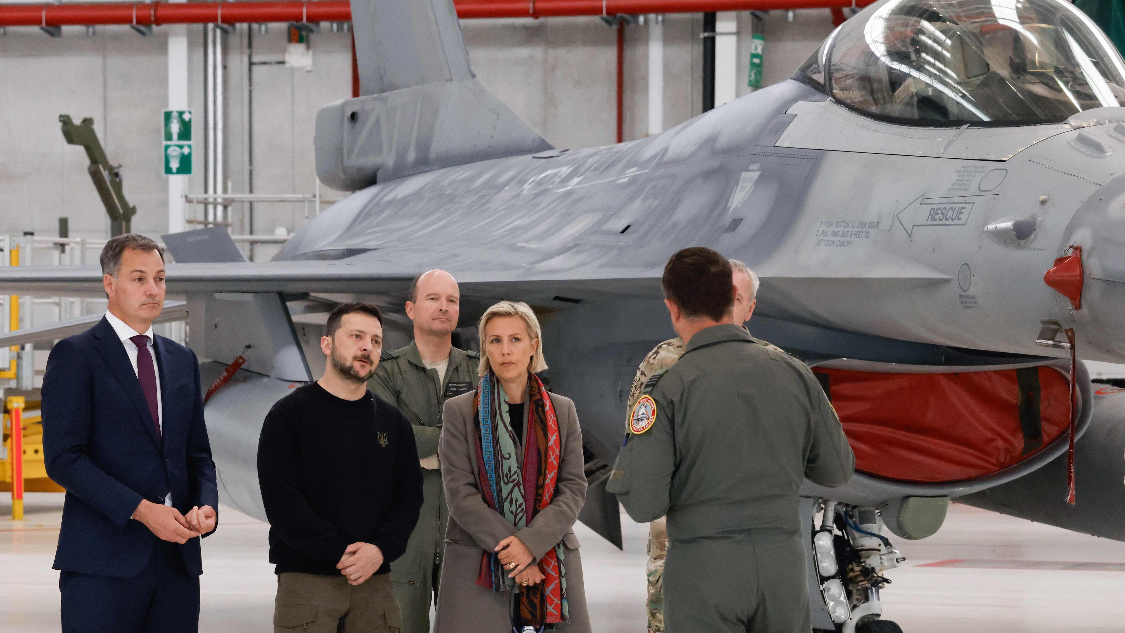 Le Premier ministre belge Alexander De Croo, le président ukrainien Volodymyr Zelensky et la ministre belge de la Défense Ludivine Dedonder échangent avec un pilote de F-16, modèle dont 30 exemplaires vont être livrés par la Belgique à l’Ukraine d’ici 2028. 