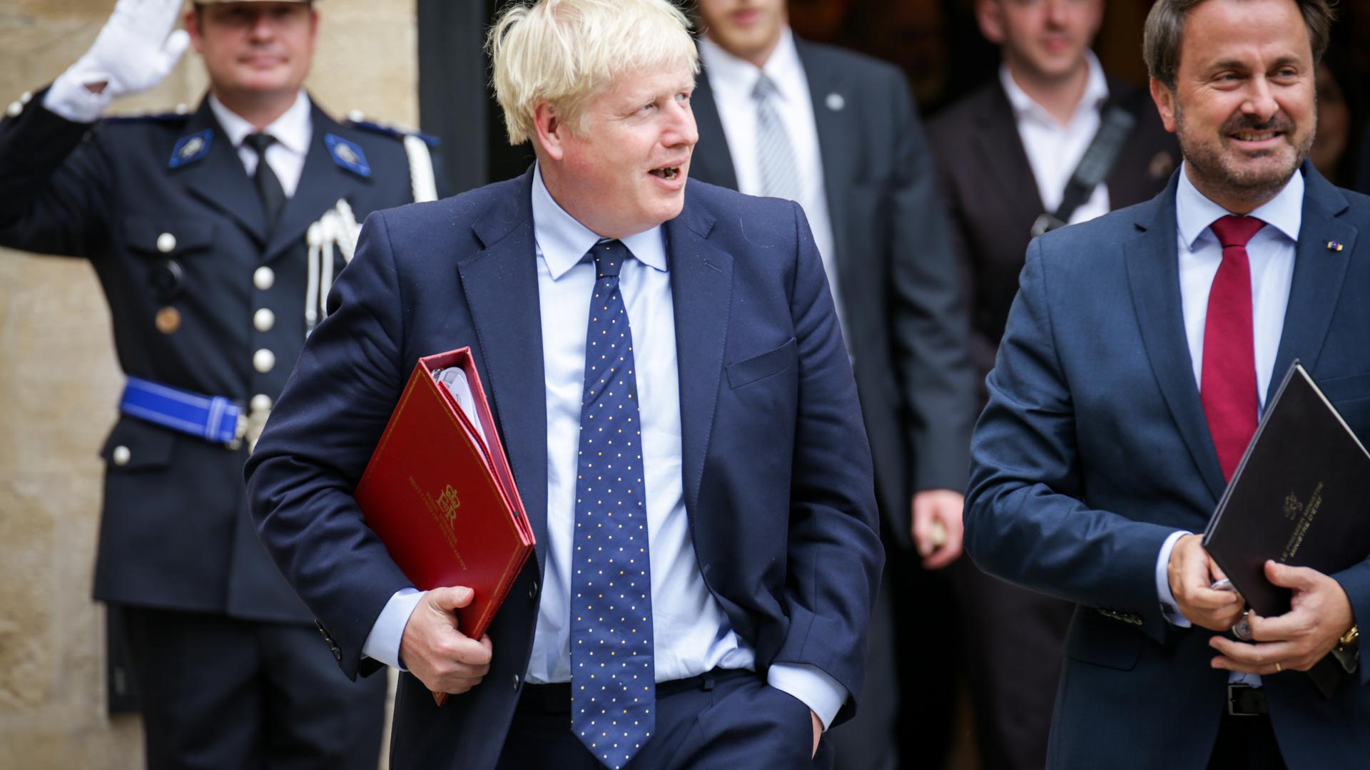 Dossier sous le bras, Boris Johnson (à g.) et Xavier Bettel sortent de leur entrevue. Les sourires sont crispés.