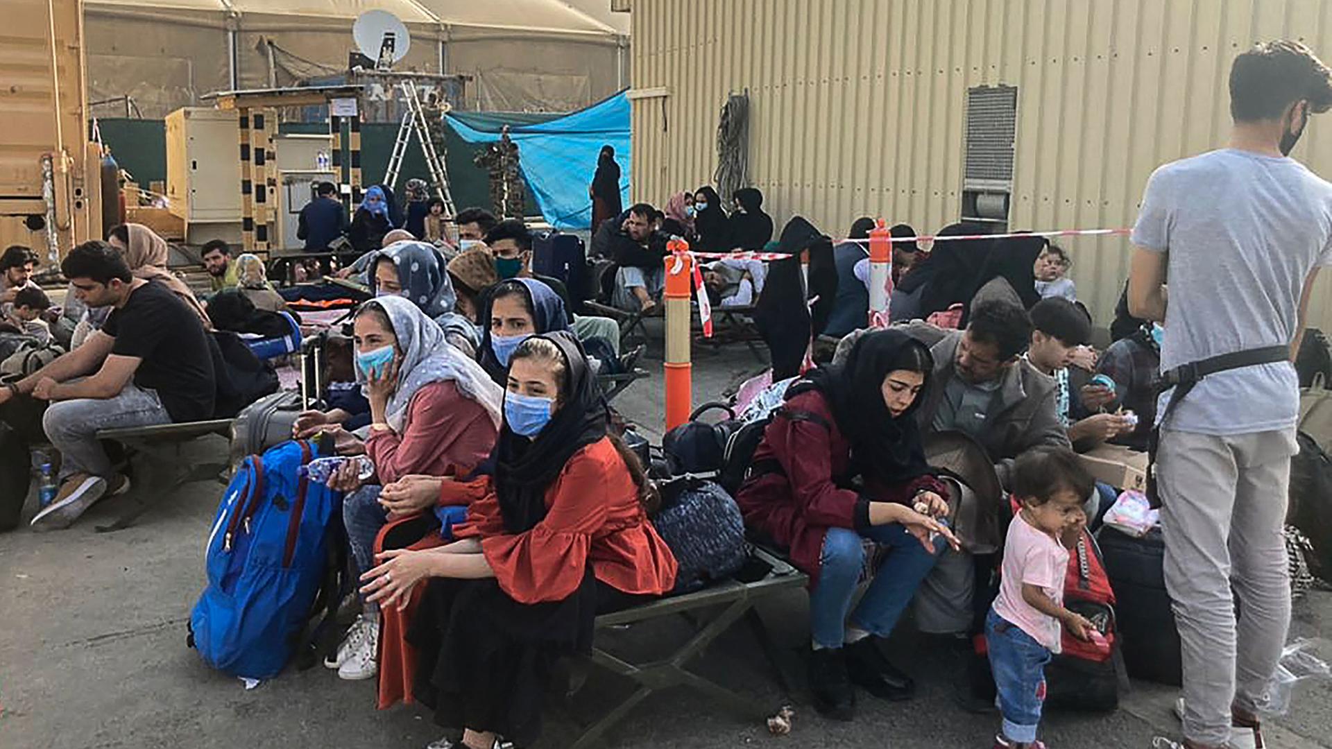 People wait to be evacuated from Afghanistan at the airport in Kabul on August 18, 2021 following the Taliban stunning takeover of the country. (Photo by - / AFP)
