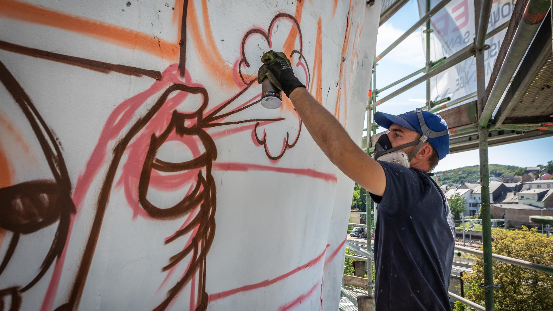 Chaque jour, Alain Welter passe jusqu'à dix heures à tagger la monumentale "toile" de ciment qui lui a été confiée.