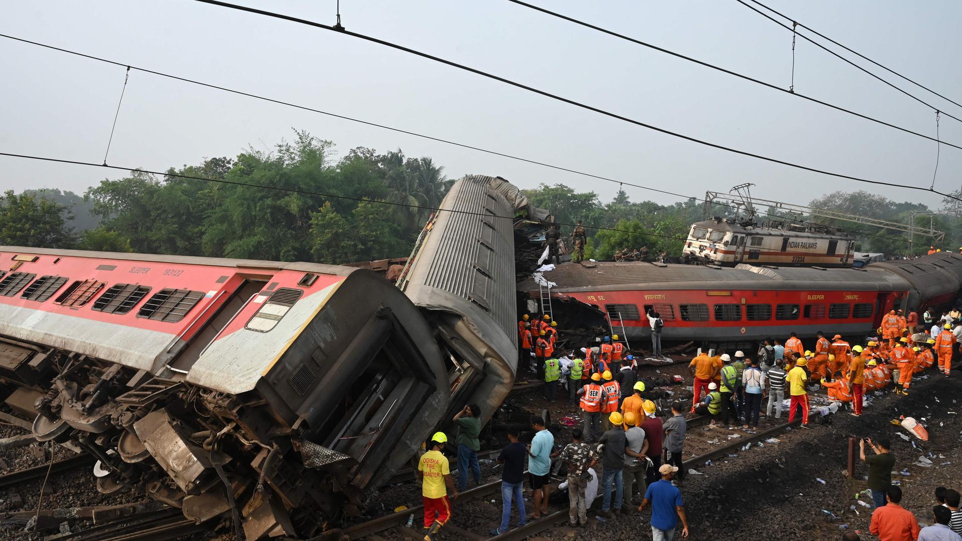 Rescue workers gather around damaged carriages during search for survivors at the accident site of a three-train collision near Balasore, about 200 km (125 miles) from the state capital Bhubaneswar in the eastern state of Odisha, on June 3, 2023. At least 288 people were killed and more than 850 injured in a horrific three-train collision in India, officials said on June 3, the country's deadliest rail accident in more than 20 years. (Photo by DIBYANGSHU SARKAR / AFP)