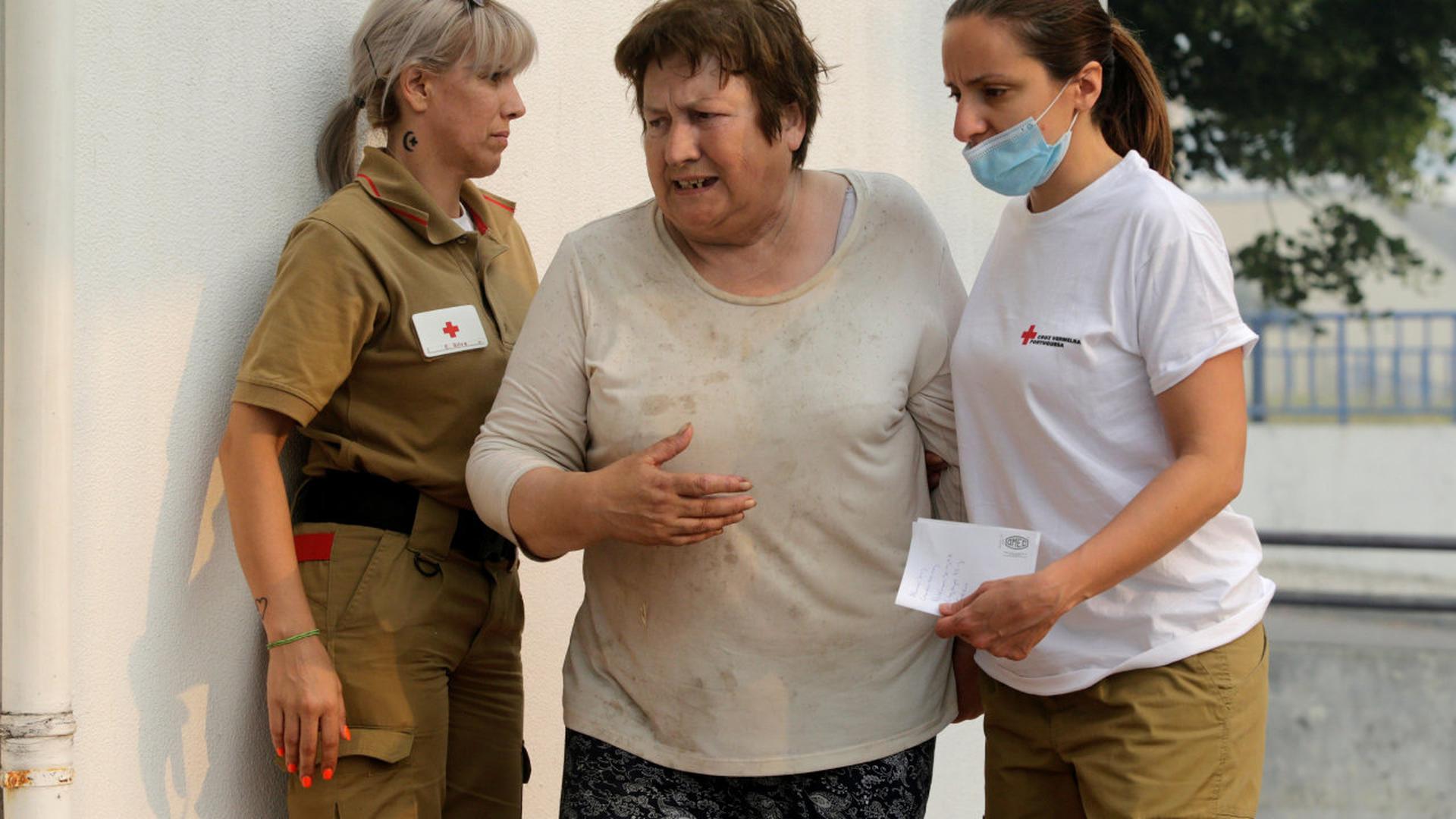Une femme prise en charge par le personnel de la Croix Rouge à Figueiro dos Vinho, lundi.