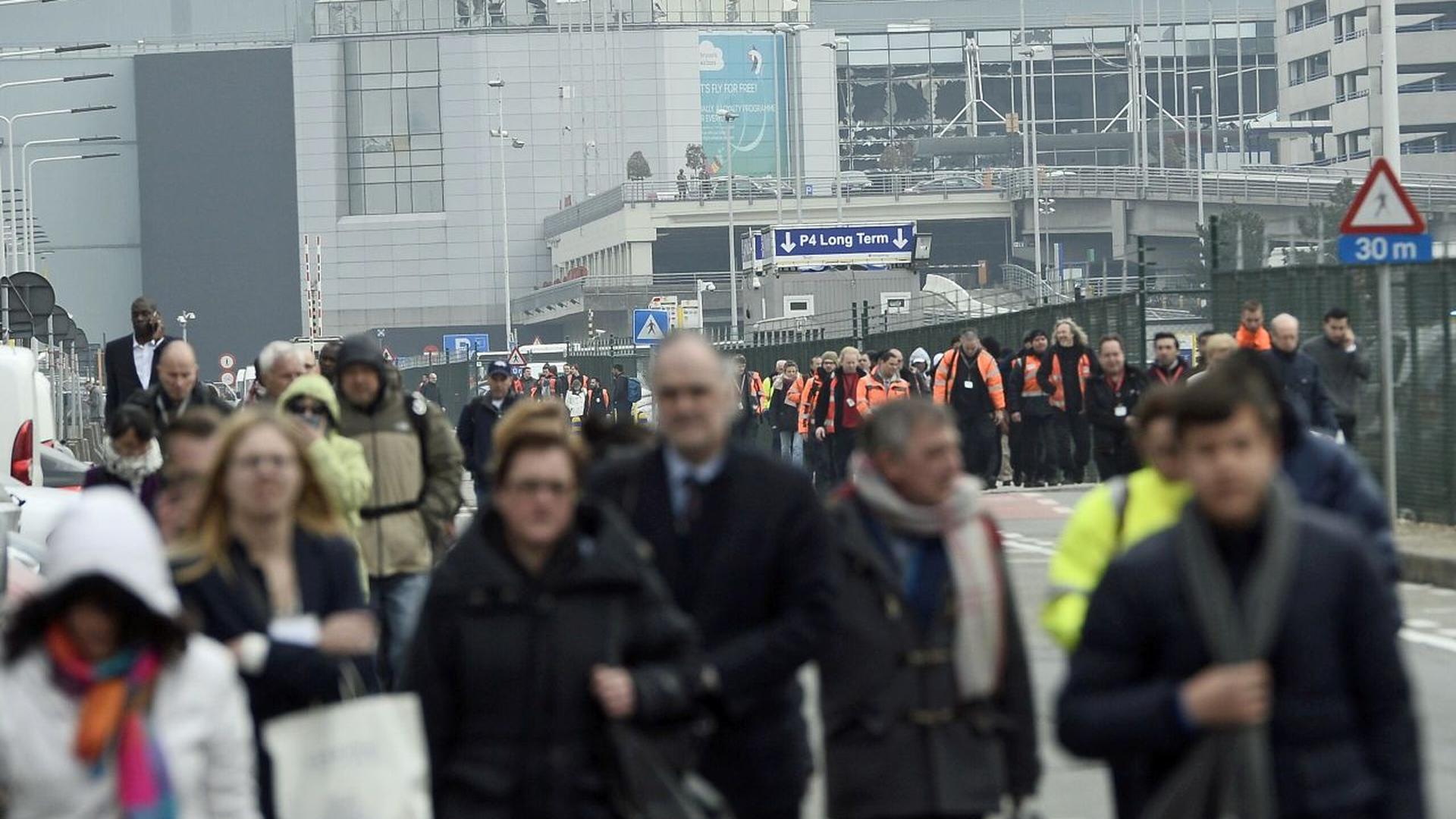 People are evacuated from Brussels Airport, in Zaventem, on March 22, 2016.  after at least 13 people have been killed by two explosions in the departure hall of Brussels Airport.  / AFP PHOTO / Belga / LAURIE DIEFFEMBACQ / Belgium OUT