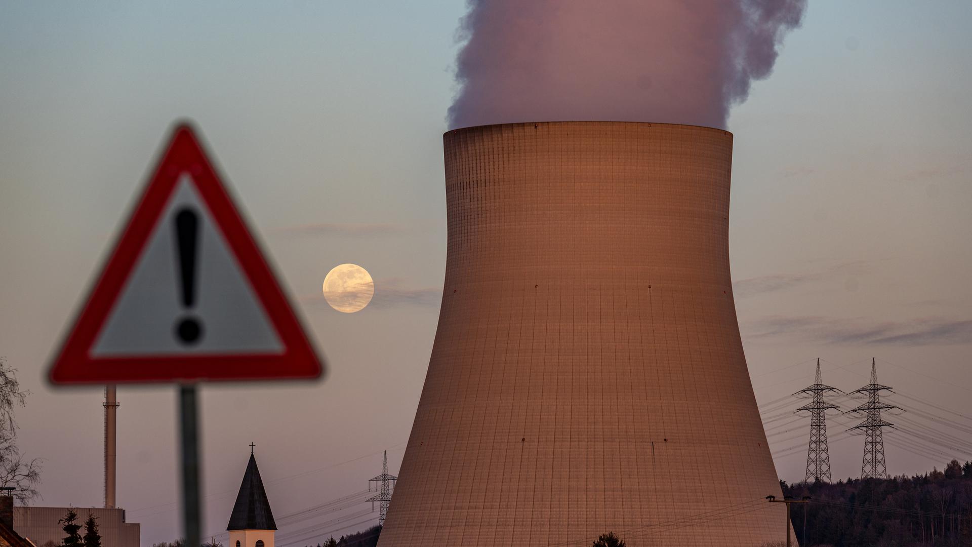 05.04.2023, Bayern, Essenbach: Wasserdampf steigt aus dem Kühltum des Kernkraftwerks Isar 2 hinter einem Warnschild. Laut Atomgesetz soll die endgültige Abschaltung des Kraftwerkes am 15. April erfolgen. Foto: Armin Weigel/dpa +++ dpa-Bildfunk +++
