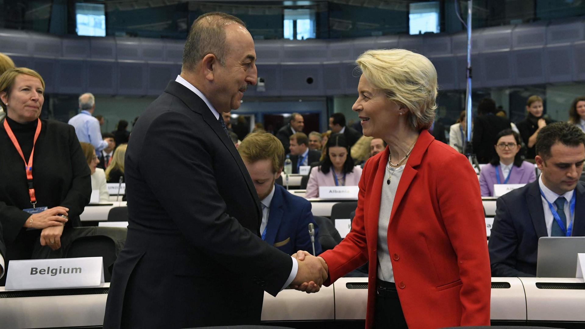 Le ministre turc des Affaires étrangères serre la main de d'Ursula von der Leyen lors de la conférence internationale des donateurs pour la Turquie et la Syrie après les séismes.