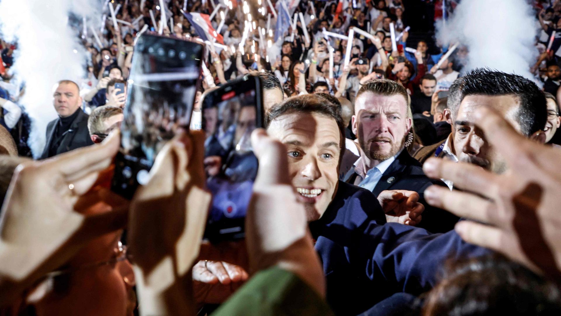 Le président français et candidat de La République en Marche (LREM) à la réélection Emmanuel Macron salue les gens alors qu'il arrive pour son premier meeting de campagne à Nanterre