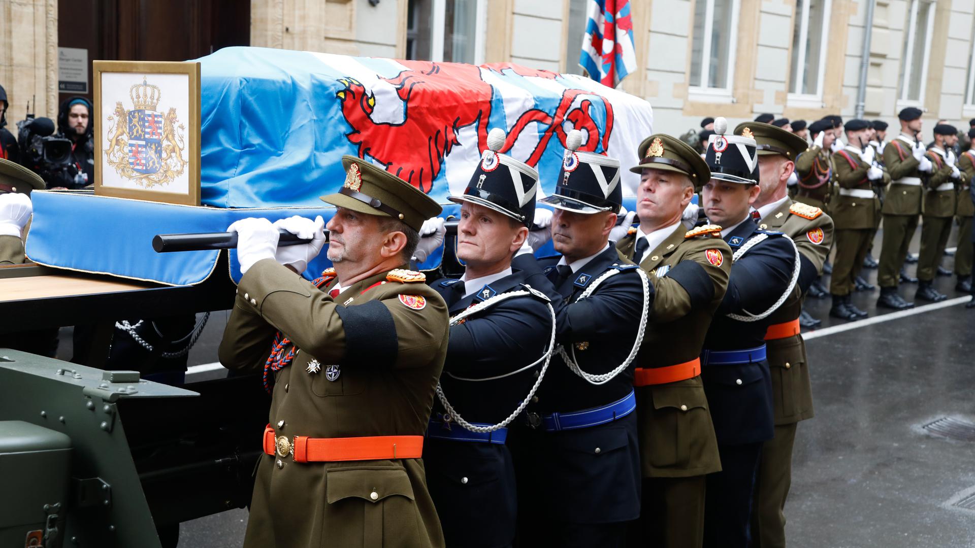Angehörige der luxemburgischen Armee und der Police grand-ducale heben den Sarg vom Kanonengestell.