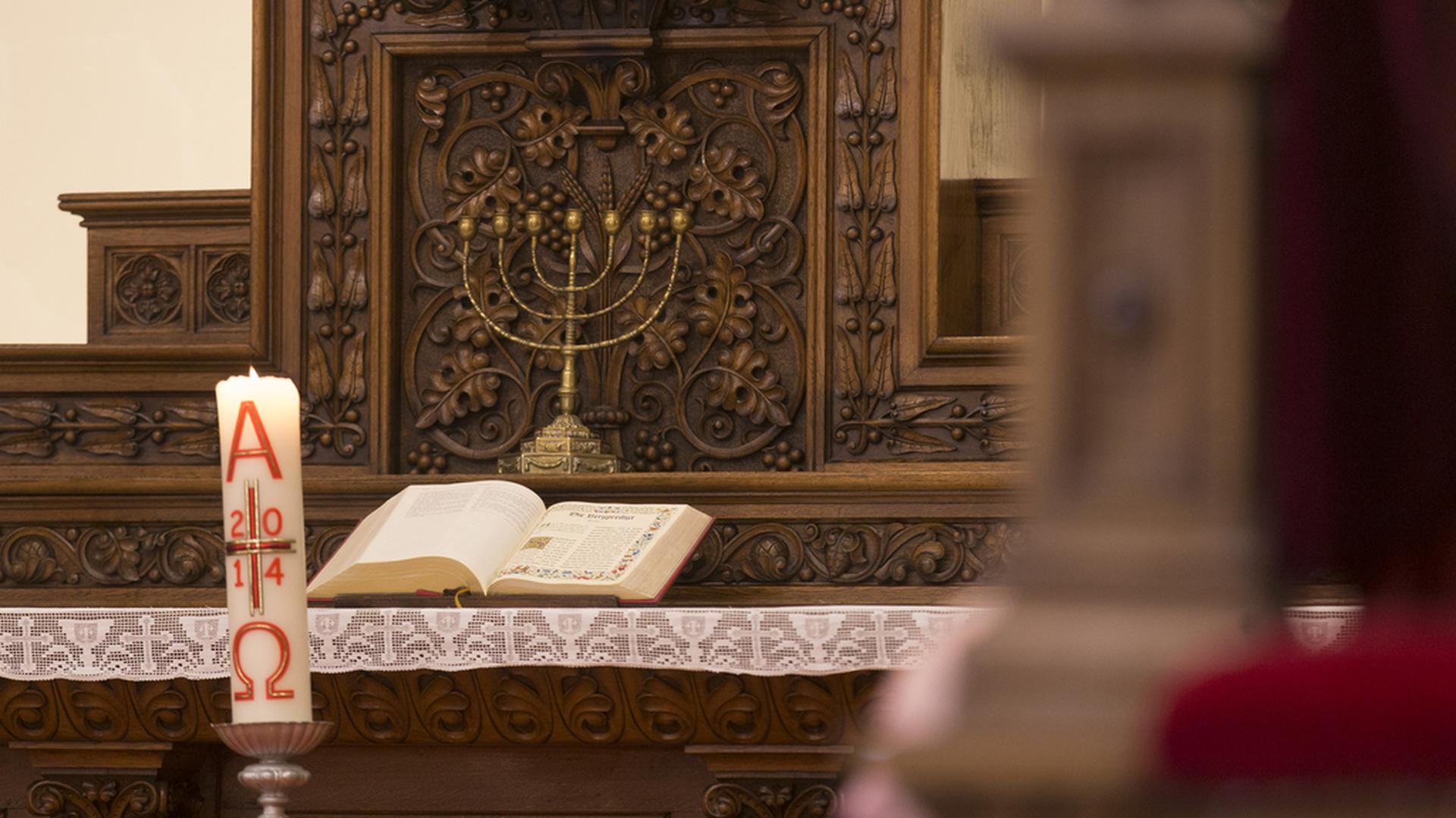 La Bible (Ancien et Nouveau testament), seule autorité reconnue par les protestants, sous un chandelier à 7 branches symbolisant le judaïsme et l'enracinement dans la foi de Jésus