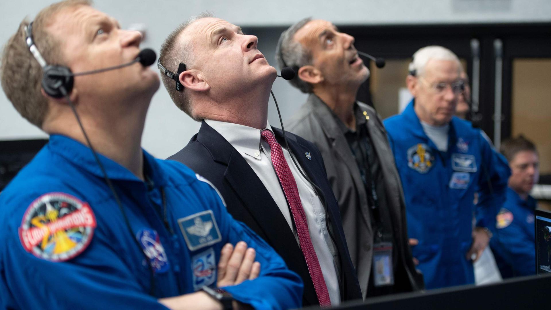 L'astronaute de la NASA Doug Hurley (à g.) le chef du bureau des astronautes Pat Forrester (2e à g.) observent le lancement de Falcon 9 et de la capsule Dragon.
