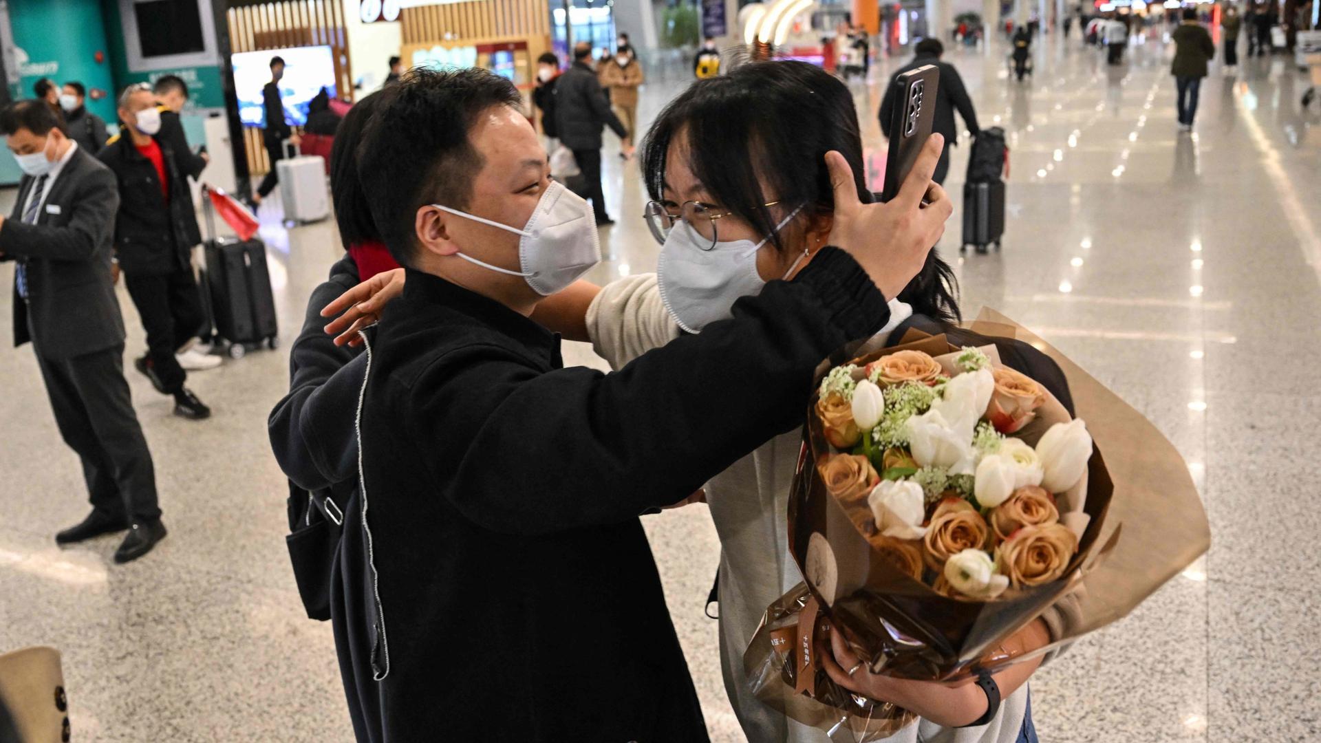 Un passager recevant une accolade en quittant la zone d'arrivée des vols internationaux à l'aéroport international de Shanghai Pudong, le 8 janvier 2023.